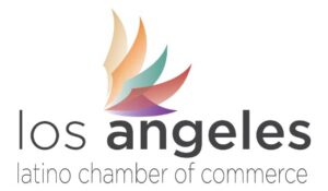 The logo features the words "los angeles" in lowercase, bold black letters, with "latino chamber of commerce" in smaller, gray lowercase text below. Above "angeles" is a stylized, multicolored wing made of overlapping curved shapes.